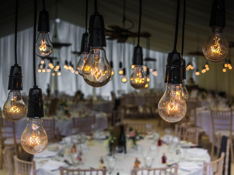 Festoon bulbs above a dressed banquet room at a themed evening