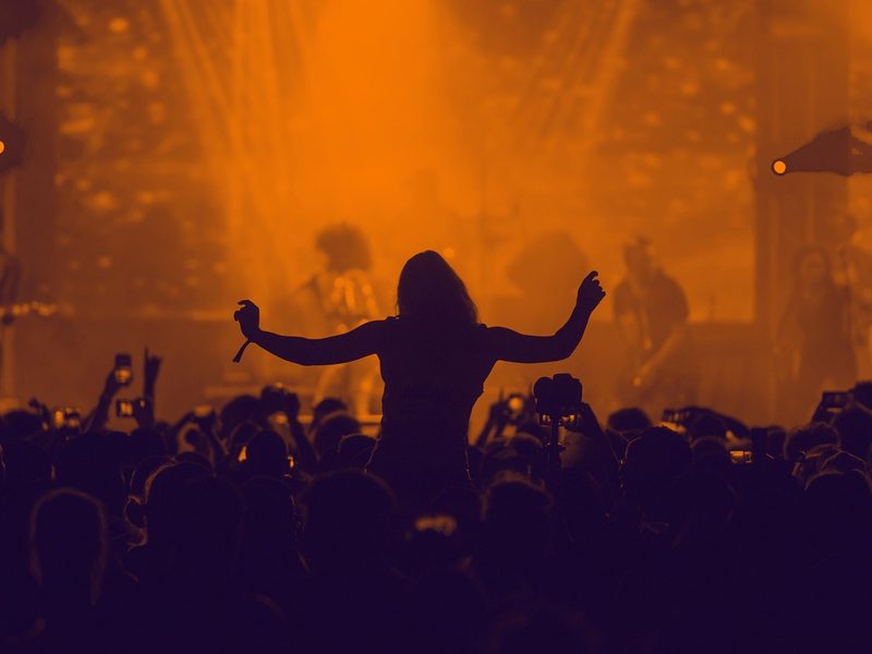 Silhouetted crowd at the closing set of a rooftop party